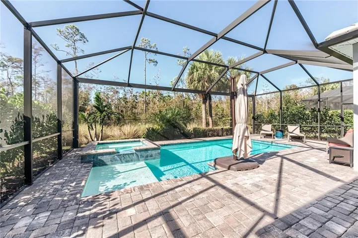 View of swimming pool featuring a patio area, a lanai, and an in ground hot tub