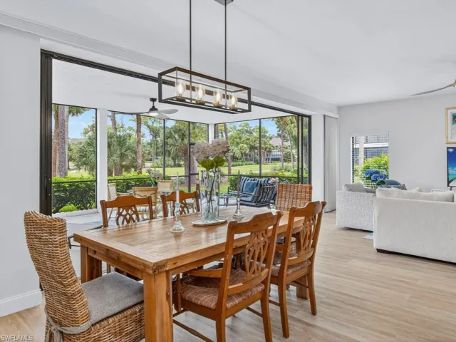 Dining area with light wood finished floors, a chandelier, and a ceiling fan