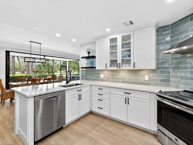 Kitchen featuring appliances with stainless steel finishes, open shelves, white cabinets, glass insert cabinets, and pendant lighting