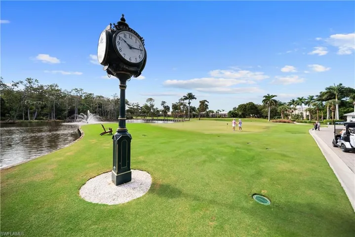 View of home's community featuring a water view, view of golf course, and a lawn