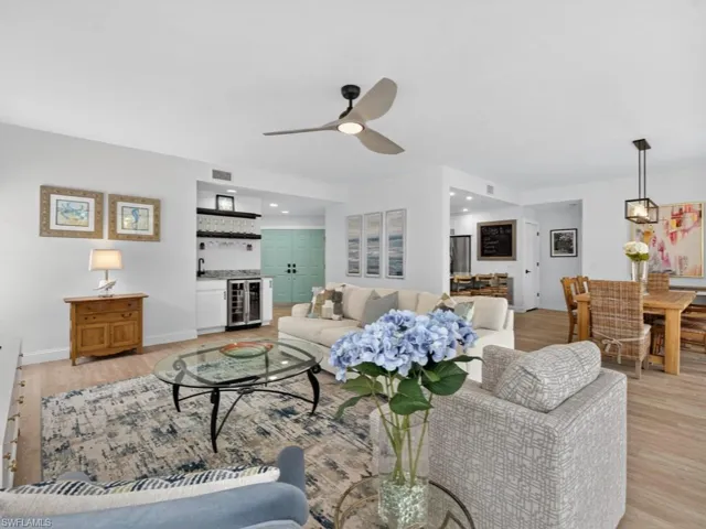 Living room with bar area, light wood-style floors, recessed lighting, and wine cooler