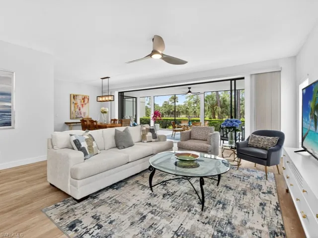Living area with light wood finished floors, a ceiling fan, and a sunroom