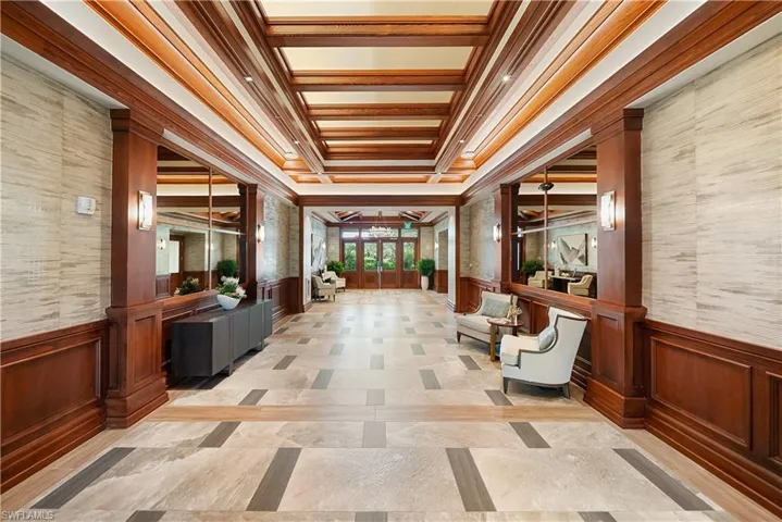 Lobby with a wainscoted wall, a decorative wall, and ornamental molding