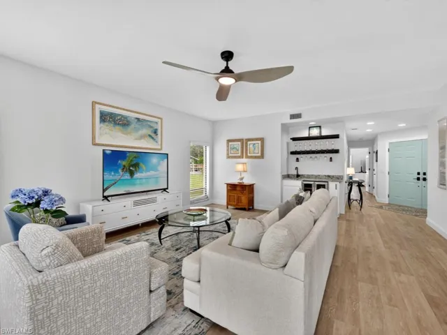 Living room featuring a dry bar, light wood-style floors, a ceiling fan, and recessed lighting