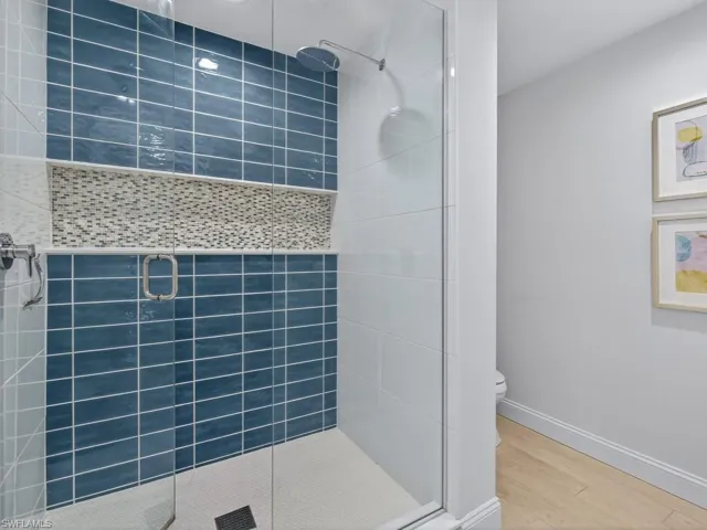 Full bath featuring a shower stall and wood finished floors