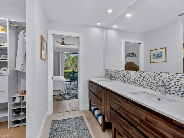 Ensuite bathroom with recessed lighting, double vanity, light wood-type flooring, ceiling fan, and tasteful backsplash