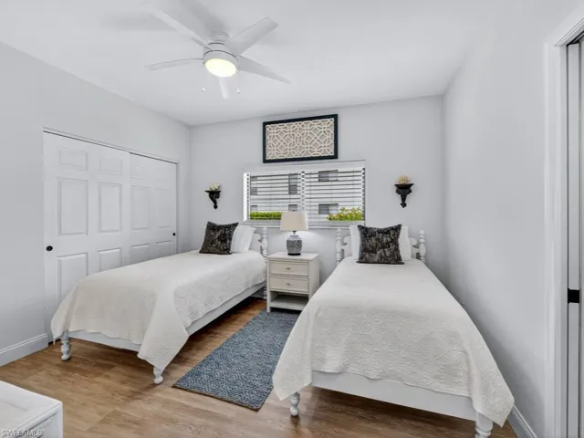 Bedroom with light wood-style flooring, ceiling fan, and a closet