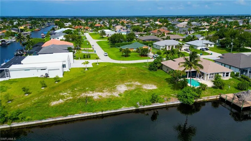 Waterfront lot featuring a sloped, grassy terrain and canal access