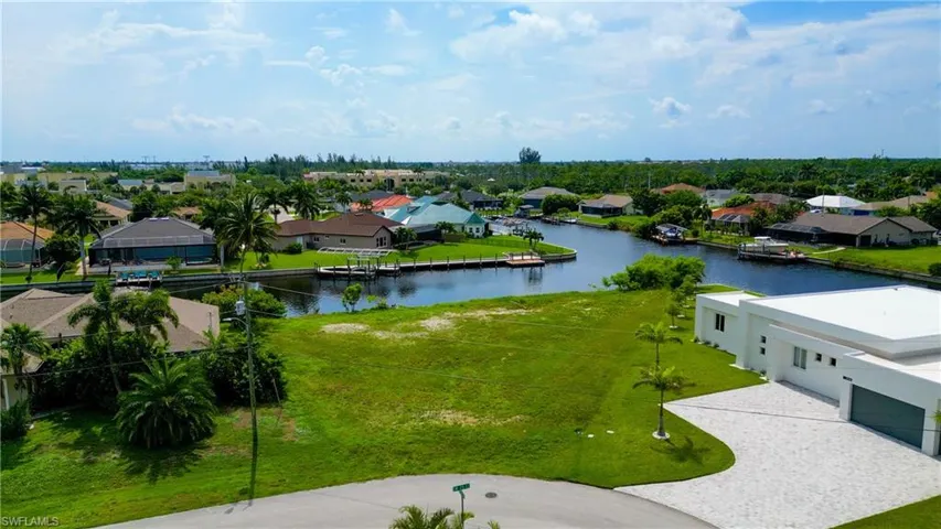 Expansive green lot featuring canal frontage and surrounding residential properties
