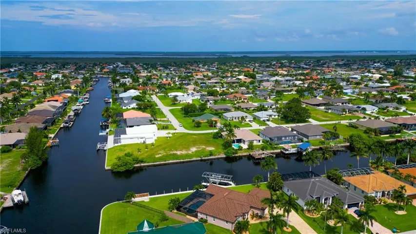 Aerial perspective showcasing multiple properties with direct canal access