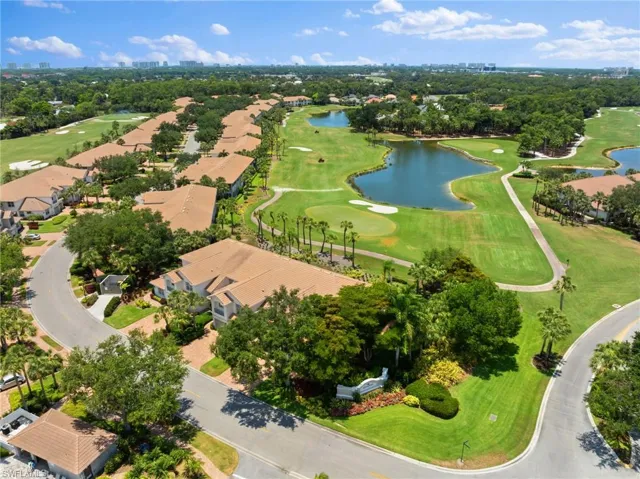 Aerial perspective of suburban area featuring a local golf course and a large body of water