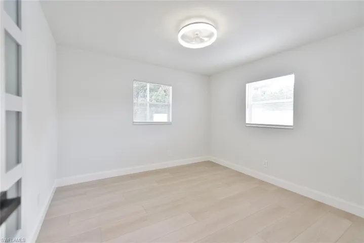 Unfurnished room with baseboards and light wood-style floors