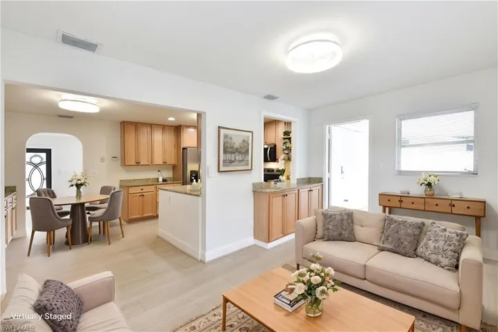Living area featuring arched walkways and light wood-type flooring