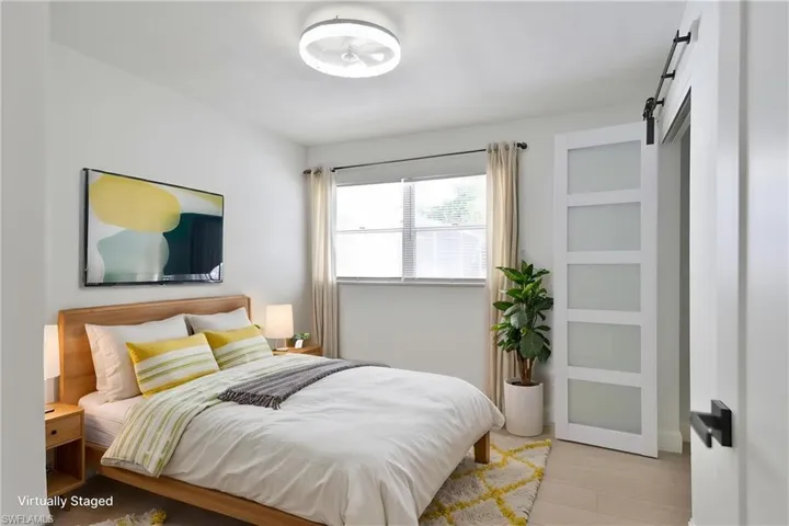Bedroom with a barn door and light wood-type flooring