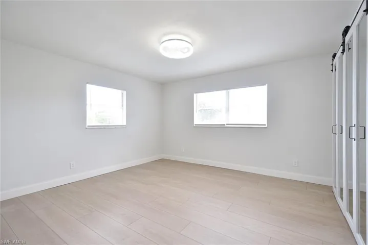 Empty room with light wood finished floors and a barn door