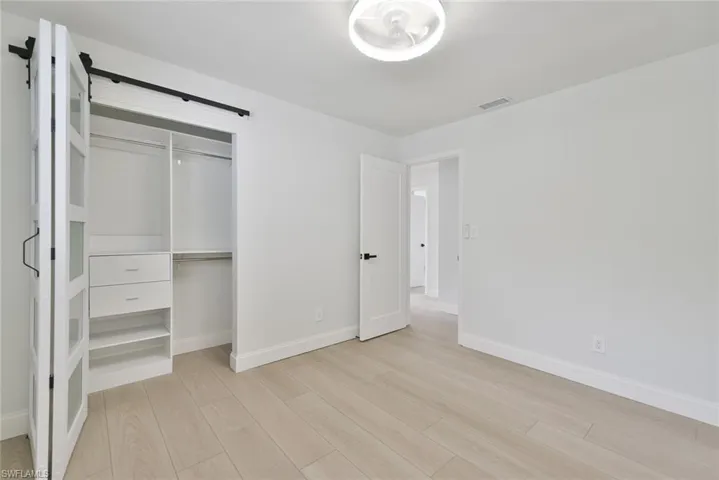 Unfurnished bedroom featuring light wood finished floors and a closet