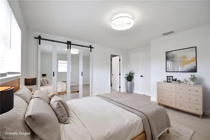Bedroom featuring a barn door and baseboards