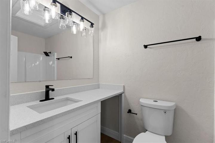 Luxurious FULL guest bathroom with black, modern, newly-installed light fixtures, water faucets.