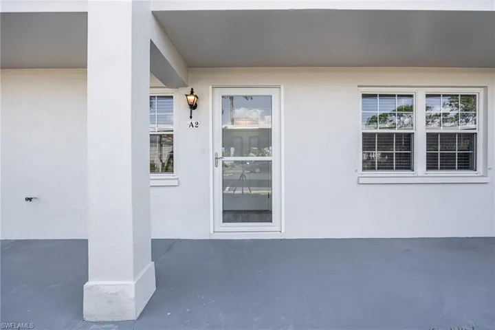 View of exterior entry with stucco siding and a patio area