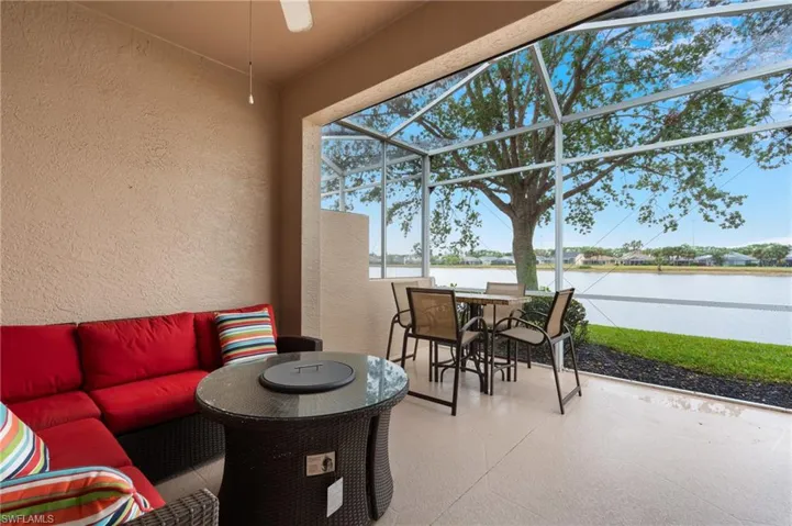 View of patio / terrace with ceiling fan, a lanai, an outdoor hangout area, and a water view