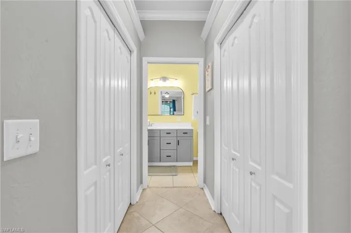 Hall featuring crown molding and light tile patterned floors
