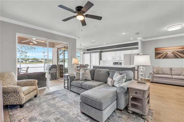 Living room featuring ceiling fan, light hardwood / wood-style flooring, and crown molding