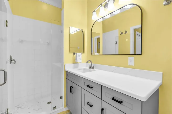 Bathroom featuring vanity and a shower with shower door