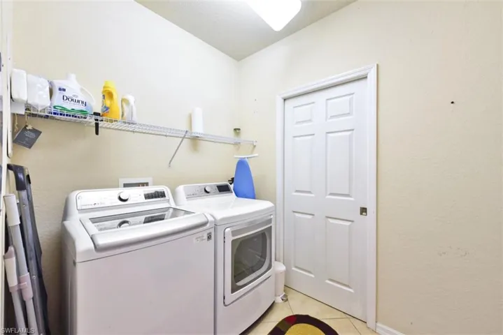 Washroom featuring washing machine and clothes dryer and light tile patterned floors