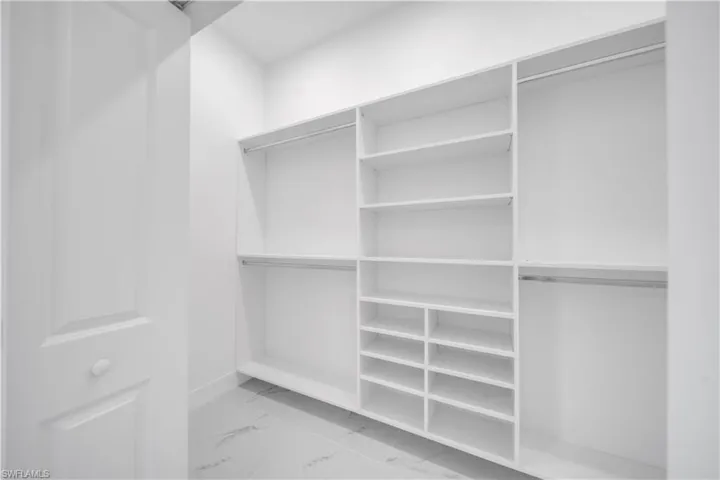 Walk in closet featuring light marble finish floors