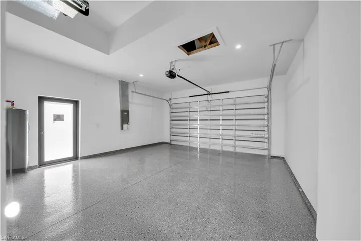 Garage featuring electric panel and recessed lighting