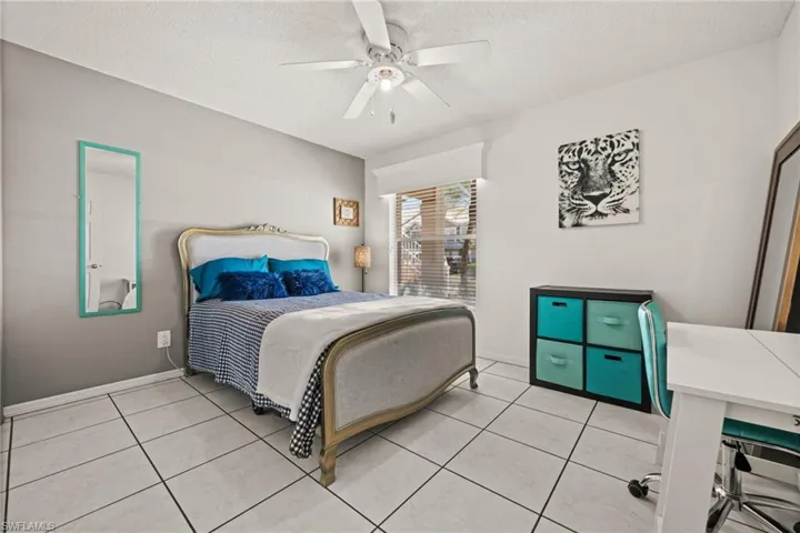 Bedroom #2 with a textured ceiling, a ceiling fan, and light tile patterned flooring