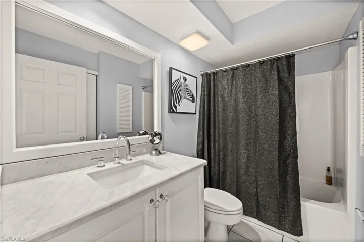 Full bathroom #2 with shower / tub combo, vanity, and light tile patterned floors