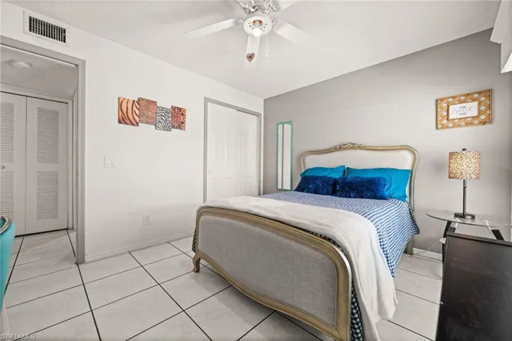 Bedroom #2 featuring light tile patterned floors, a ceiling fan, and a closet.