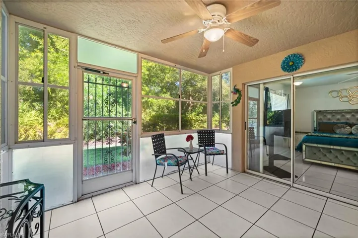 Sunroom with ceiling fan leading to the Primary Bedroom