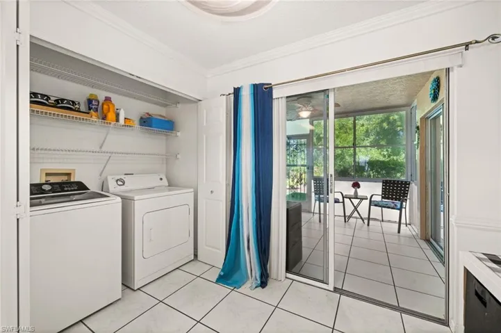 Laundry area with washing machine and clothes dryer leading to the screened lanai.