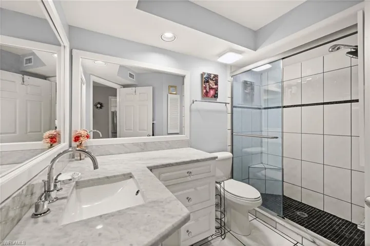 Bathroom featuring vanity, a stall shower, recessed lighting, and tile patterned floors