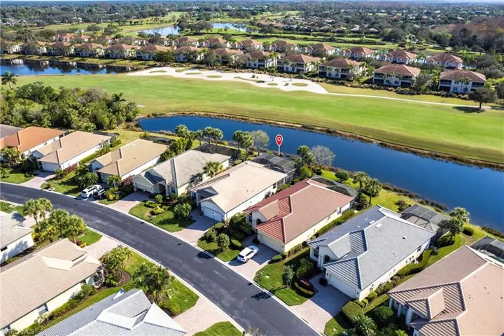 Aerial view of residential area with a local golf course and a large body of water