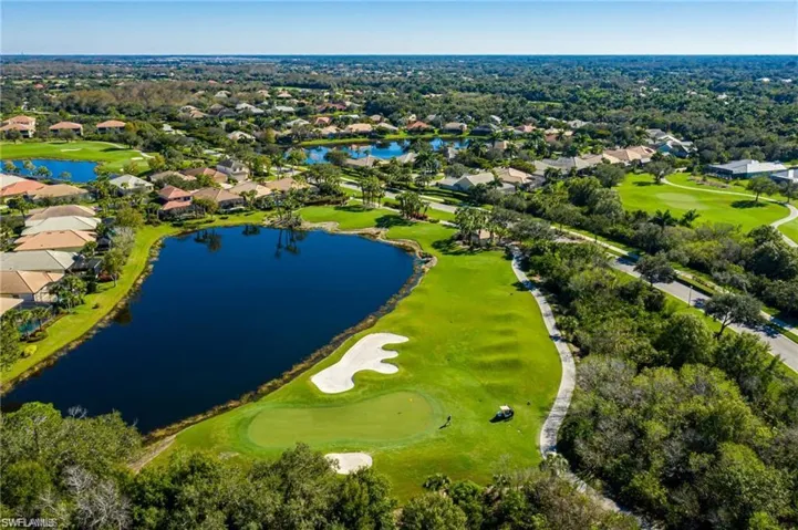 Aerial perspective of suburban area with a local golf course and a large body of water