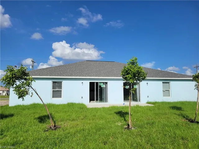 Rear view of property with a lawn