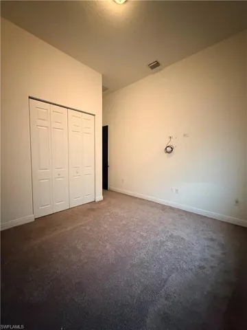 Spacious room featuring neutral carpet flooring and light-toned walls