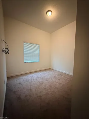 Carpeted interior room with neutral-toned walls