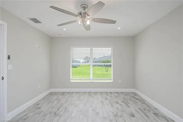 Unfurnished room featuring light wood-type flooring and ceiling fan
