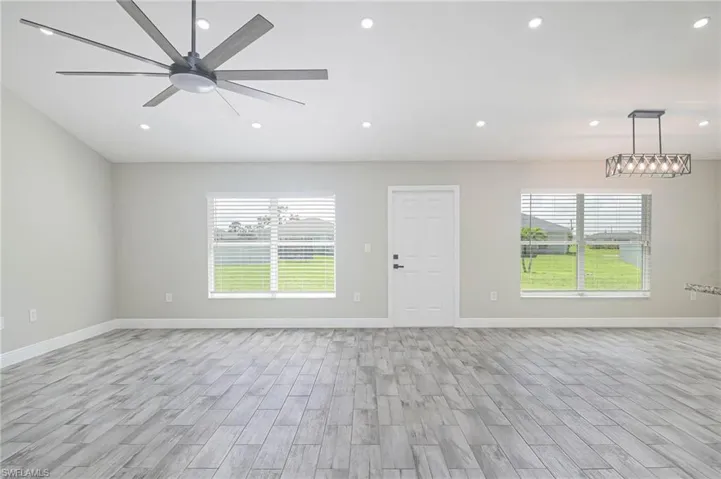 Unfurnished living room with ceiling fan, light hardwood / wood-style floors, and a healthy amount of sunlight