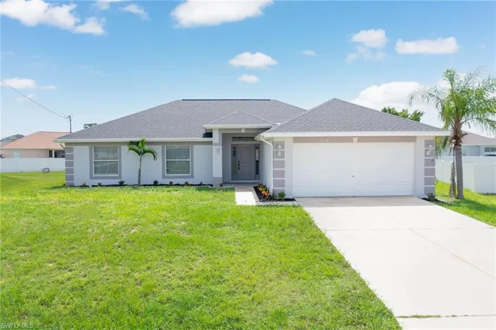 Single story home featuring a garage and a front lawn
