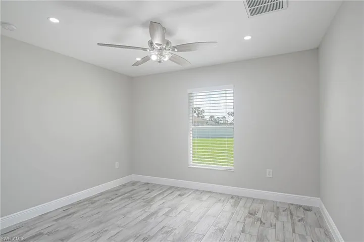 Empty room with light wood-type flooring and ceiling fan