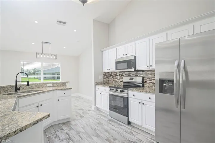 Kitchen with white cabinets, stainless steel appliances, and sink