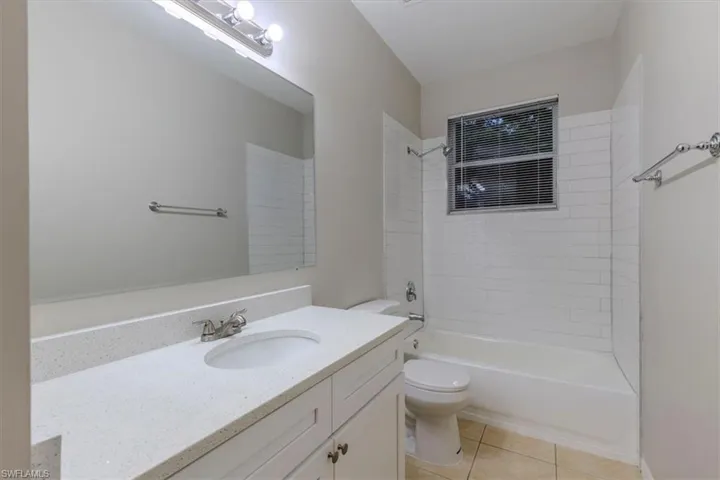 Bathroom featuring vanity, shower / bathtub combination, and light tile patterned floors