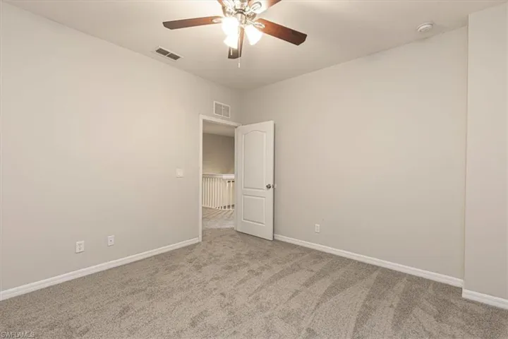 Spare room featuring light colored carpet and ceiling fan