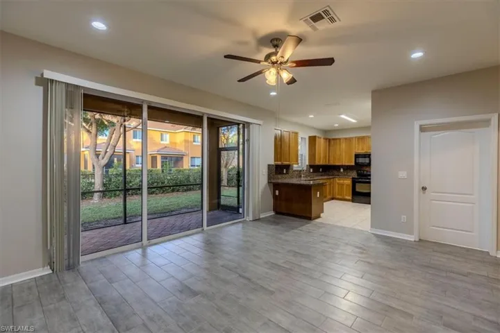 Kitchen featuring brown cabinets, open floor plan, recessed lighting, tasteful backsplash, and black appliances
