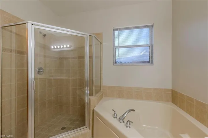 Full bath featuring a stall shower and a bath